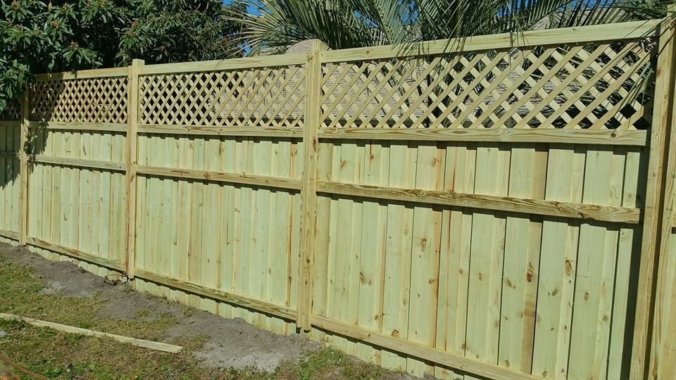 wood privacy fence with lattice wood work on top edge
