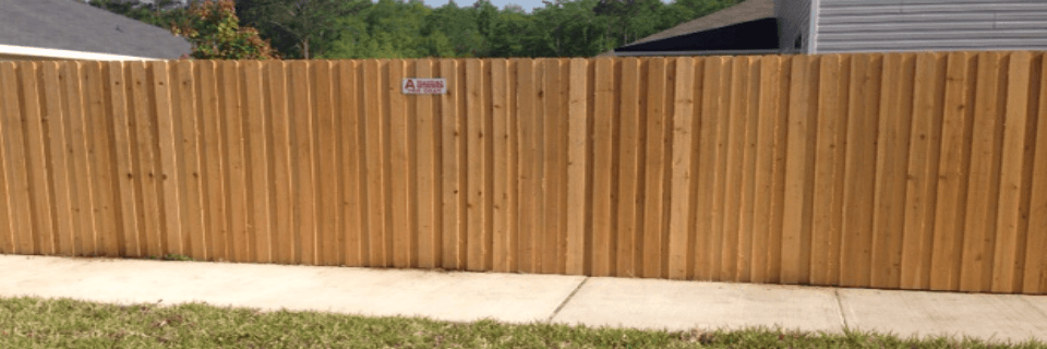 wooden privacy fence with A Norman Fence Co's sign