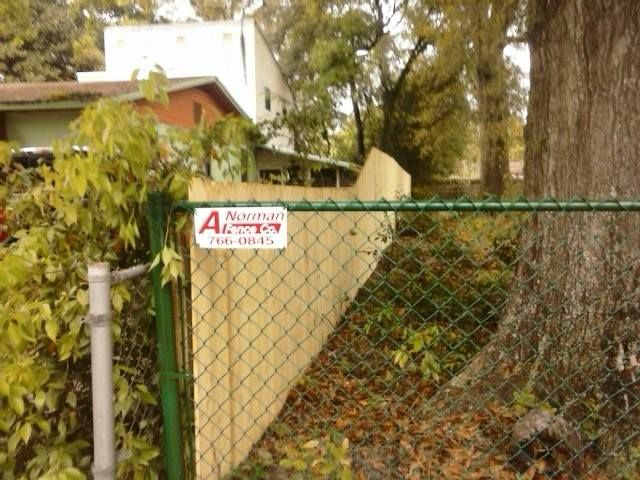 green chain link fence with A Norman Fence Co's sign